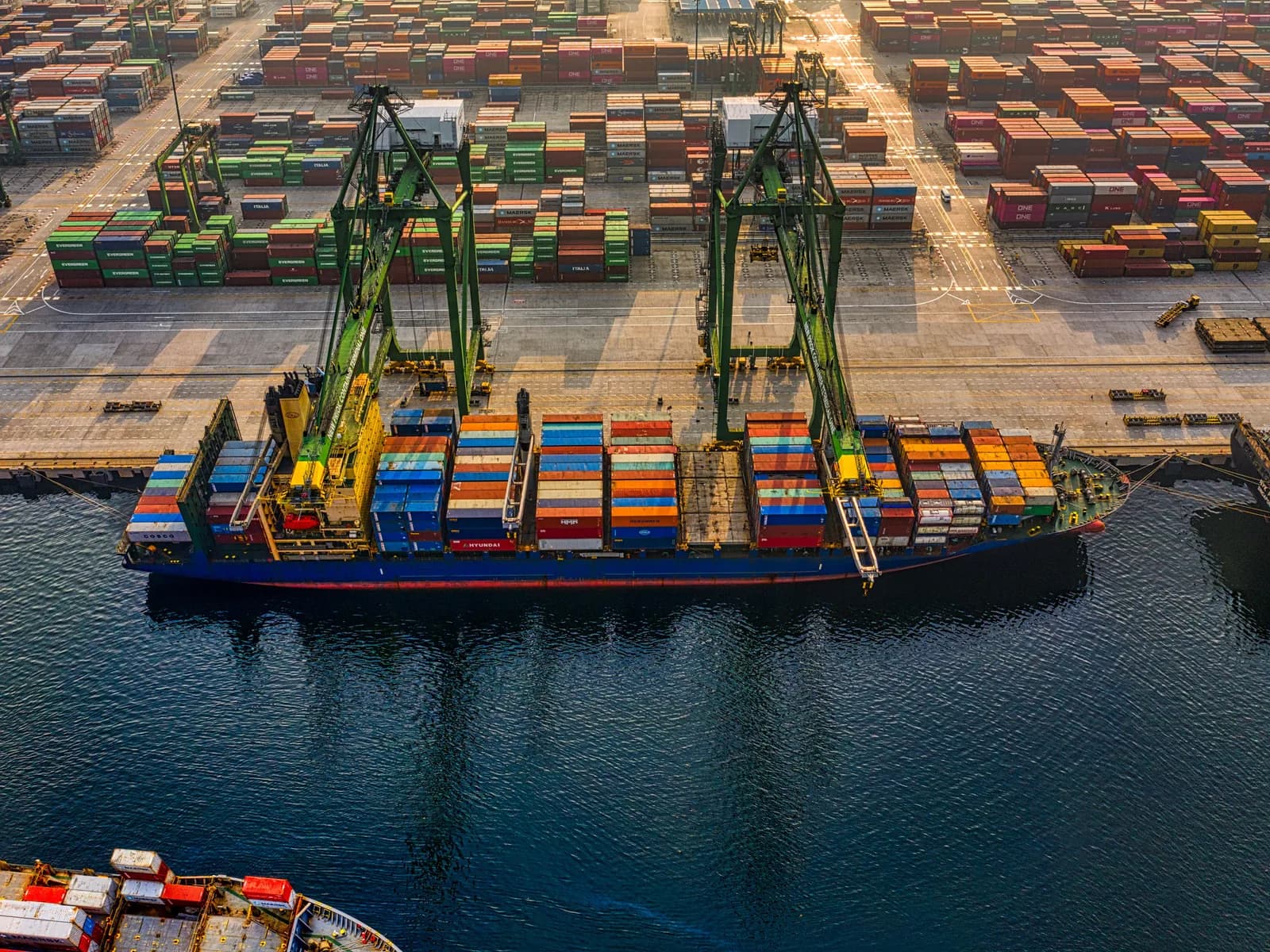 Overhead view of a container vessel at port with gantry cranes